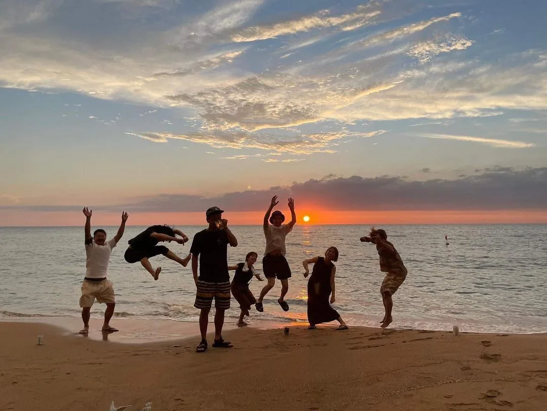 夕暮れの海岸で遊ぶ人々